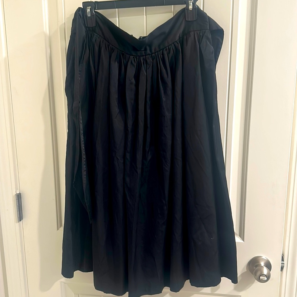 Simple black elegant skirt, some pleating but falls to a loose taper, pockets
